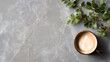 © wannee - A cozy coffee cup with latte art on a stylish marble surface, surrounded by fresh greenery for a tranquil vibe.
