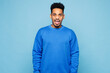 © ViDi Studio - Young sad angry mad indignant dissatisfied man of African American ethnicity wearing sweatshirt casual clothes isolated on plain pastel light blue cyan background studio portrait. Lifestyle concept.