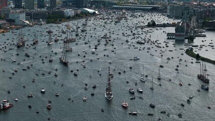 Wall Mural - Aerial timelapse of thousands of boats streaming from Amsterdam as light breaks through the clouds