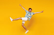 © ViDi Studio - Full body young cheerful man wear blue beach t-shirt casual clothes listen to music in headphones raise up hands leg dance isolated on plain yellow orange background studio portrait Lifestyle concept