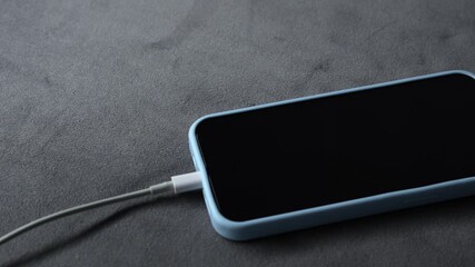 Charging a dead battery on a smartphone.
A switched-off phone is charging.
A charging cable is connected to a smartphone.
A modern smartphone is charging.