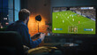© Gorodenkoff - Caucasian Man Spending Time at Home in the Evening, Playing a Soccer Video Game on a Big TV Set at Home. Young Male Sitting on a Sofa, Using a Controller to Defeat a Rival Football Team Online