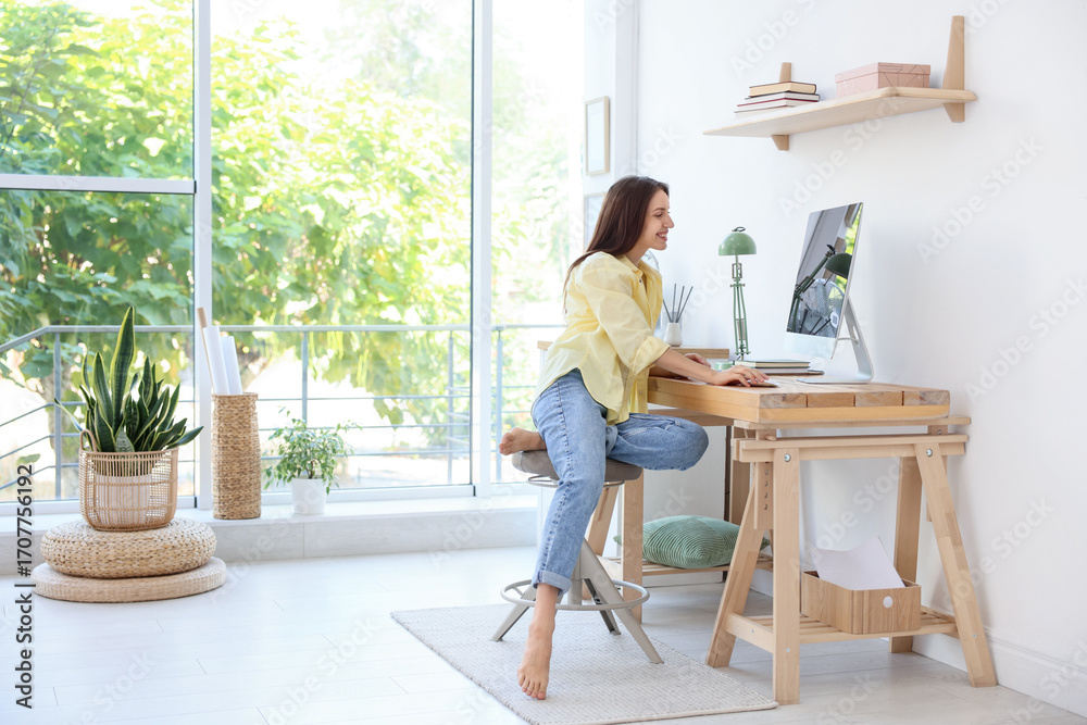 Woman using computer at wooden desk indoors, space for text. Home ...