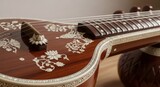 Closeup of a traditional indian sitar, a plucked string instrument with intricate inlay work and a rich wooden finish