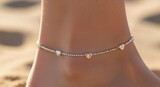 Closeup of a delicate silver anklet with small heart charms adorning a womans ankle on a sandy beach