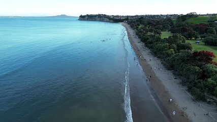 Wall Mural - Aerial view of people enjoying the ocean in the evening at the New Zealand Beach