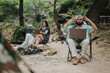 © qunica.com - Friends enjoying a camping trip in nature while using technology, highlighting outdoor and digital dynamics.
