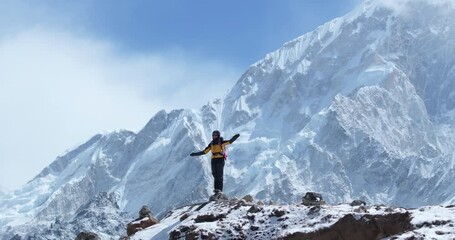 Wall Mural - Drone shot of a tourist standing tall amidst Lhotse peak on the Everest Base Camp trek in Khumbu, Nepal. A 360° aerial reveals snow-capped Himalayas, breathtaking scenery, and high-altitude adventure
