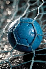 Vibrant blue soccer ball nestled in a frosty goal net sparkling with icy drops