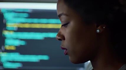 Close Up of Focused Young Woman Coding with Illuminated Computer Screen in Background