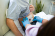 Hands of nurse wearing gloves and changing bandage on patient's wound after surgery