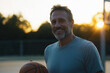 © Arman Zhenikeyev - AI. Smiling mature man with basketball ball