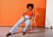 © valbar STUDIO/Stocksy - Woman in Orange Top