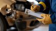 © photo for everything - Assessing vehicle damage after accident. Inspector documents damages on a clipboard. Repair estimate being written, with car visible in the background.