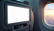 © miss irine - Blank white airplane monitor screen on passenger seat mockup. Modern aircraft interior features entertainment system display, window view of sunset sky. Travel technology for communication, journey.