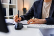 © Jovo Jovanovic/Stocksy - Man writing in notebook at desk with computer peripherals.