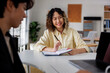 © Jovo Jovanovic/Stocksy - Smiling woman takes notes during a meeting.