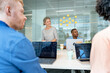 © Santi Nuñez/Stocksy - Business team meeting in modern office with laptops and sticky notes