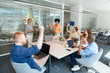 © Santi Nuñez/Stocksy - Multicultural team raising hands during brainstorming session
