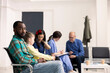 © DC Studio - Young black man waiting in hospital reception area for clinical consultation. Portrait of african american patient calmly seated in modern medical lobby, ready for doctors appointment.