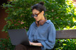© Roman Shalenkin/Stocksy - Young female using laptop to make research on park