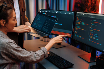 Serious of IT developers discussing intelligent website development coder system running data online two screens with laptop showing information network at neon light room at modern office. Infobahn.