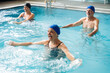 © Santi Nuñez/Stocksy - Senior adults doing water aerobics in swimming pool