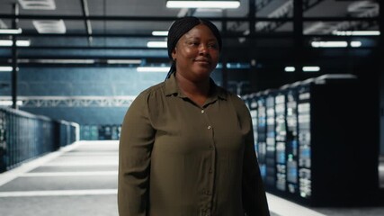 Software developer walking in data center, checking hardware for system stability. System administrator overseeing server farm room, monitoring infrastructure rigs, camera B