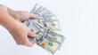 © JuliaDorian - Financial Freedom Hands Holding a Stack of Hundred Dollar Bills on White Background
