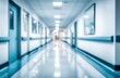 © RefinedEdge - A blurred, bright and sterile hospital hallway with shiny floors and handrails, receding into the distance, under artificial light