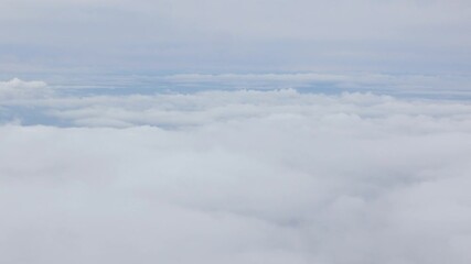 Wall Mural - Aerial view above the clouds and sky inspiration concept in cinematic breathtaking aerial flying over white fluffy cloudscape in high altitude sky with fresh clean air and blue skies on background.