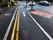 Urban street in Manchester with bicycle lane and pedestrian walkway during daytime
