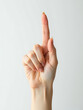 © Deborah - delicate female hand rests pure white background index finger extended pointing sharply upwards lit soft diffused