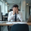 © Pete - Stressed businessman covering face in office at desk with laptop. Manager shows frustration, depression, cephalalgia from job overload. Tired executive dealing with work problems burnout, feeling