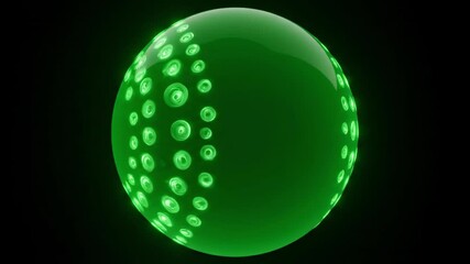 Green circular object with smaller circular lightreflecting patterns in a black setting