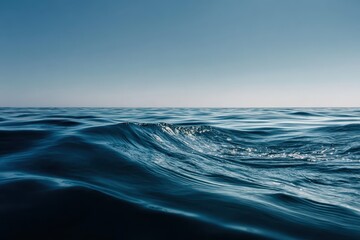Wall Mural - Gentle ocean waves rolling quietly over a deep blue sea during midday under a clear sky