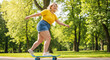 © akridiy - Joyful plus size woman skateboarding in park