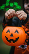 © Inspire Shots Hub - Child's hands hold orange pumpkin Halloween candy bucket, smiling face visible, dark background with green bokeh, showcasing festive spirit and trick-or-treating tradition