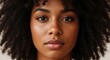© PixMix - Closeup portrait of a young black woman with natural curly hair and expressive eyes, looking directly at the camera with a neutral expression, showcasing her clear skin and subtle makeup