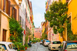 Colorful architecture in Trastevere district in Rome, Italy. Yellow buildings and green flowers on cozy street at sunny day.