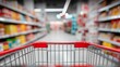 © vilaiporn - A shopping cart in a grocery aisle, surrounded by colorful shelves filled with various products.