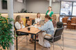 © svetograph - Teamwork Collaboration Meeting, Modern Office, Daytime: Staff strategizing at table to achieve company growth.