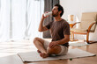 © Maria Vitkovska - Man drinking protein shake after exercising yoga at home