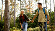 © BGStock72 - Happy couple hiking through a forest trail while holding hands in the bright sunlight during a warm afternoon