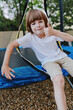 © SHOTPRIME STUDIO - Happy boy giving a thumb up while sitting on a trampoline, wearing a white shirt, enjoying a sunny day outdoors with a playful atmosphere.