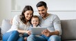 © gegen - Happy young family with a baby watching a tablet