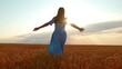 © Victoriia - Young girl joyfully runs through wheat field at sunset. Concept of woman's dream in nature. Female farmer, arms outstretched, runs through wheat field. Happy, free woman runs through ears of wheat