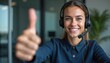 © Vadym - Young woman wears headset, smiles, and gives a thumbs up. She works in a call center and offers good service. Her positive attitude and pro appearance make her a great employee. She looks happy.