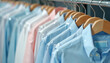 © Vadym - Row of neatly hung shirts in plastic covers. Light blue, white, and pink dress shirts hang on wooden hangers in a clean retail space. Pro garment care and storage.