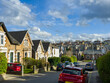A residential area, in an urban or suburban setting, a mix of housing types and styles, a combination of taller apartment buildings and rows of houses with pitched roofs, a blend of architectural. 